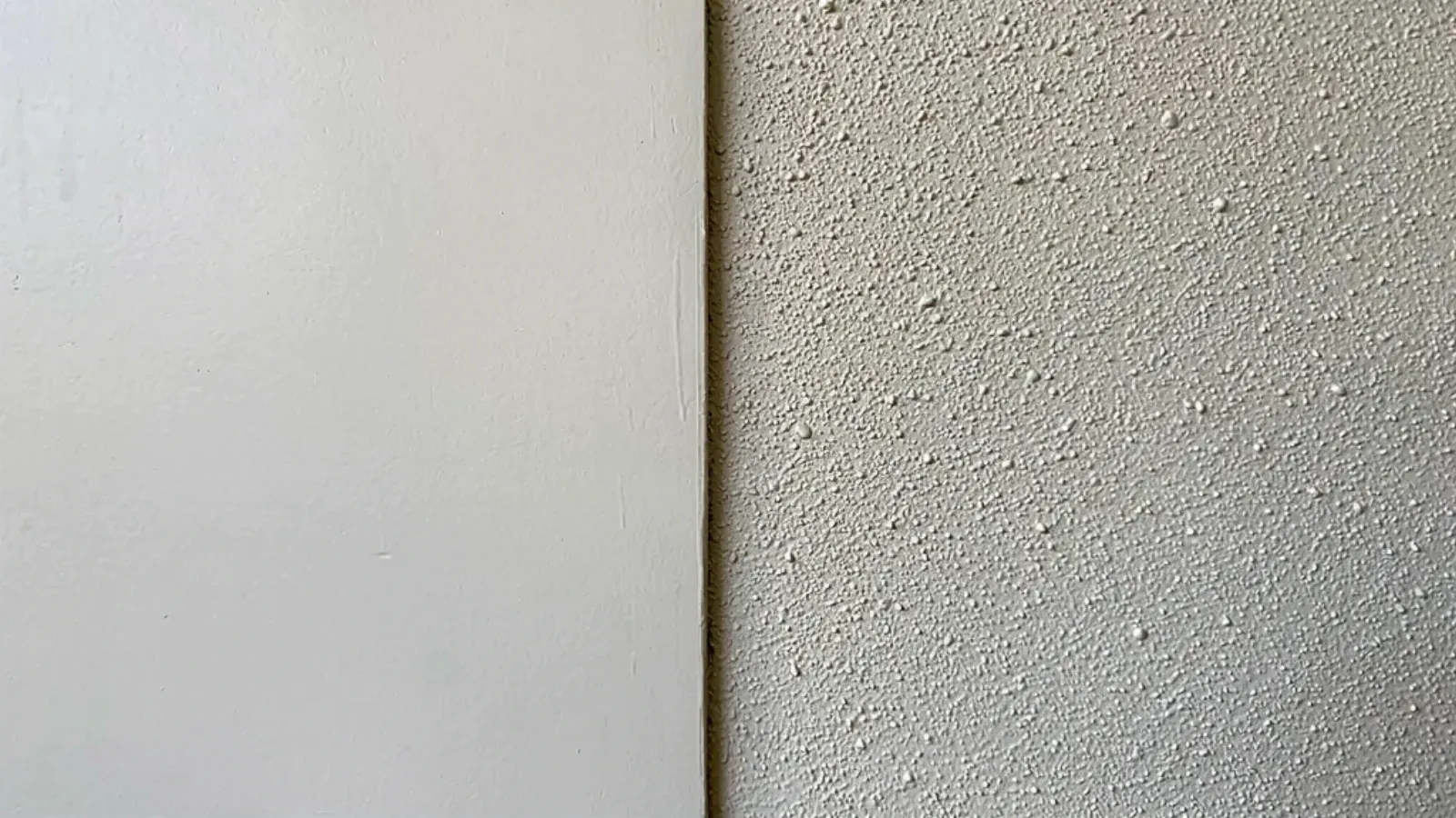 A smooth flat wall finish meeting a fine orange peel spray texture along a vertical line